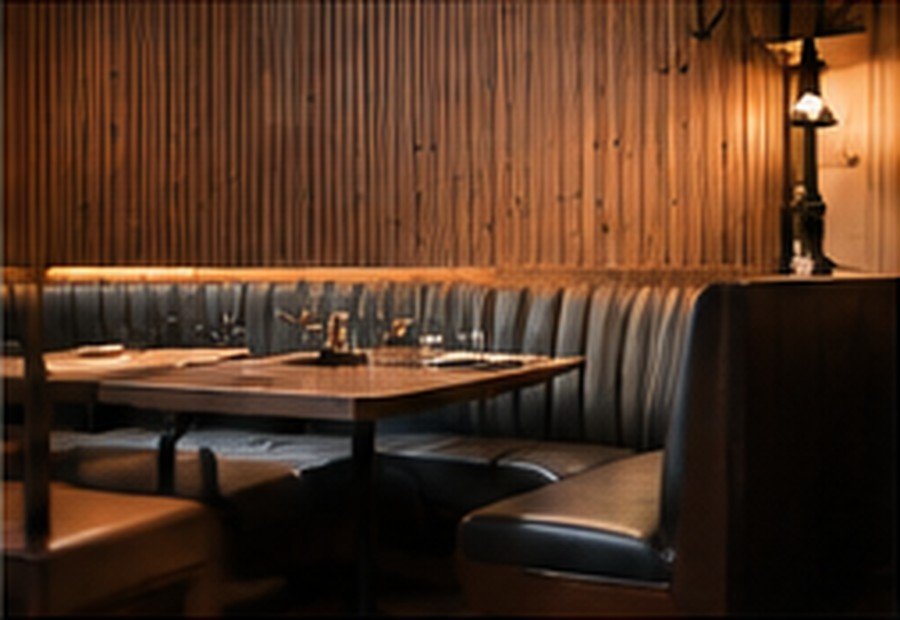 Dark leather banquette booth seating with a wood table against a ribbed wood wall